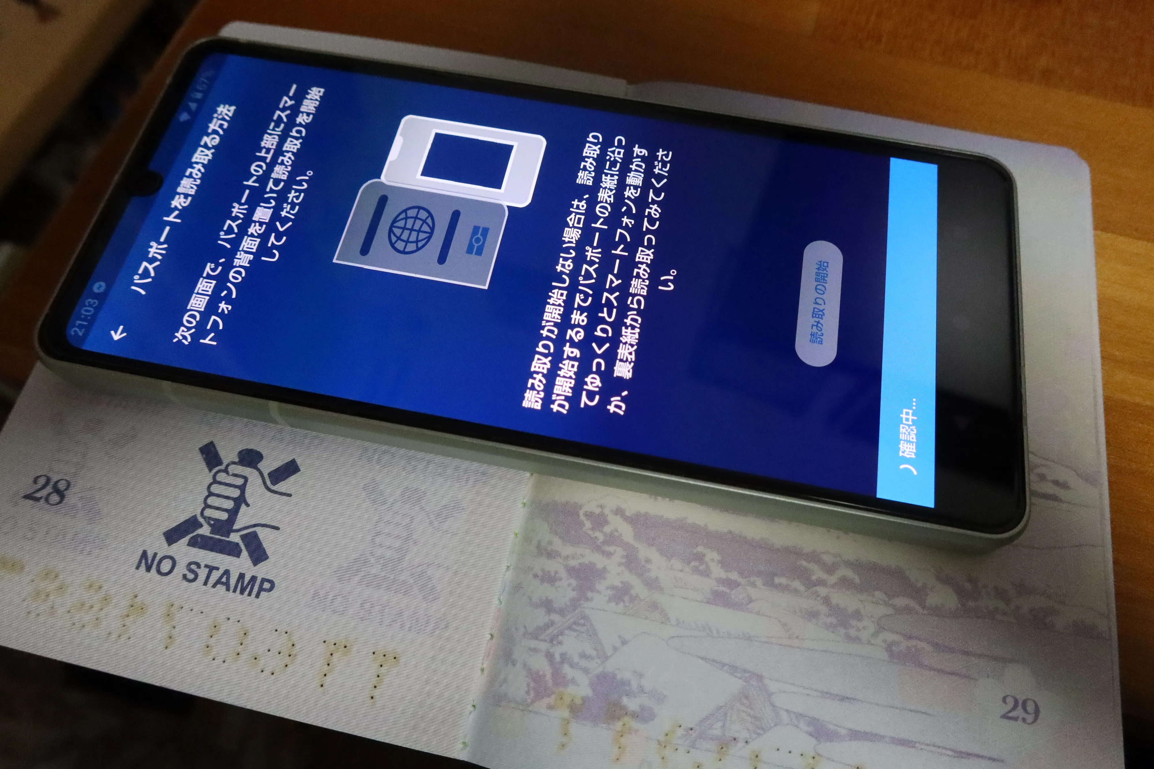 スマートフォンでパスポートのICチップを読み取り、渡航手続きアプリに登録する様子